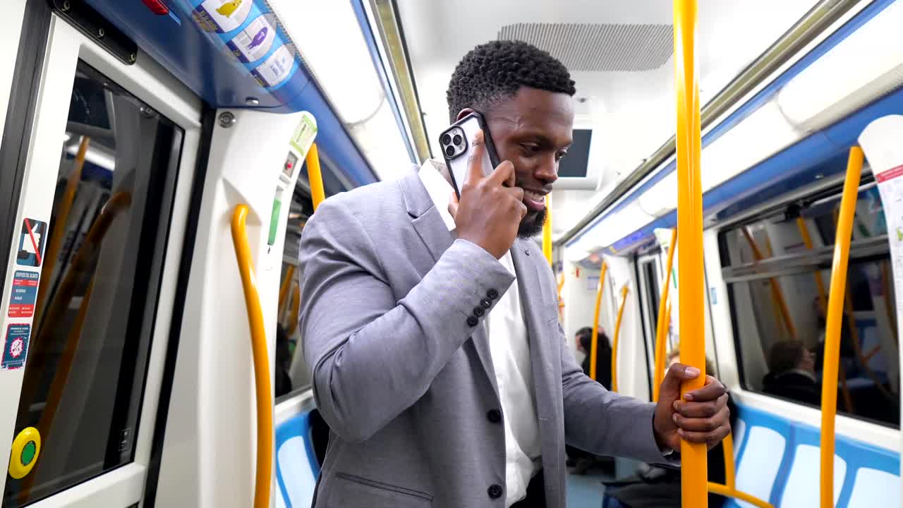 Mand i jakkesæt taler i telefon i en metro