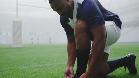 rugby player tying shoelaces in the stadium 4k