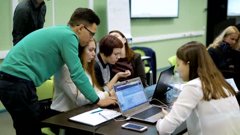 smart man helping a group of girl students in computer lab