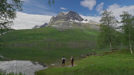 two hikers by a serene mountain lake