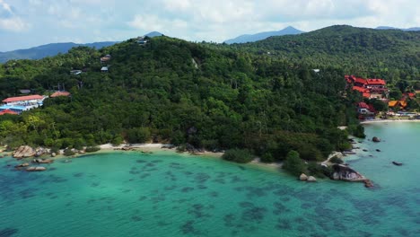 Holiday-resorts-on-coastline-of-tropical-island-with-trees-forest,-secret-beaches-and-cliffs,-turquoise-sea-in-koh-phangan,-Thailand