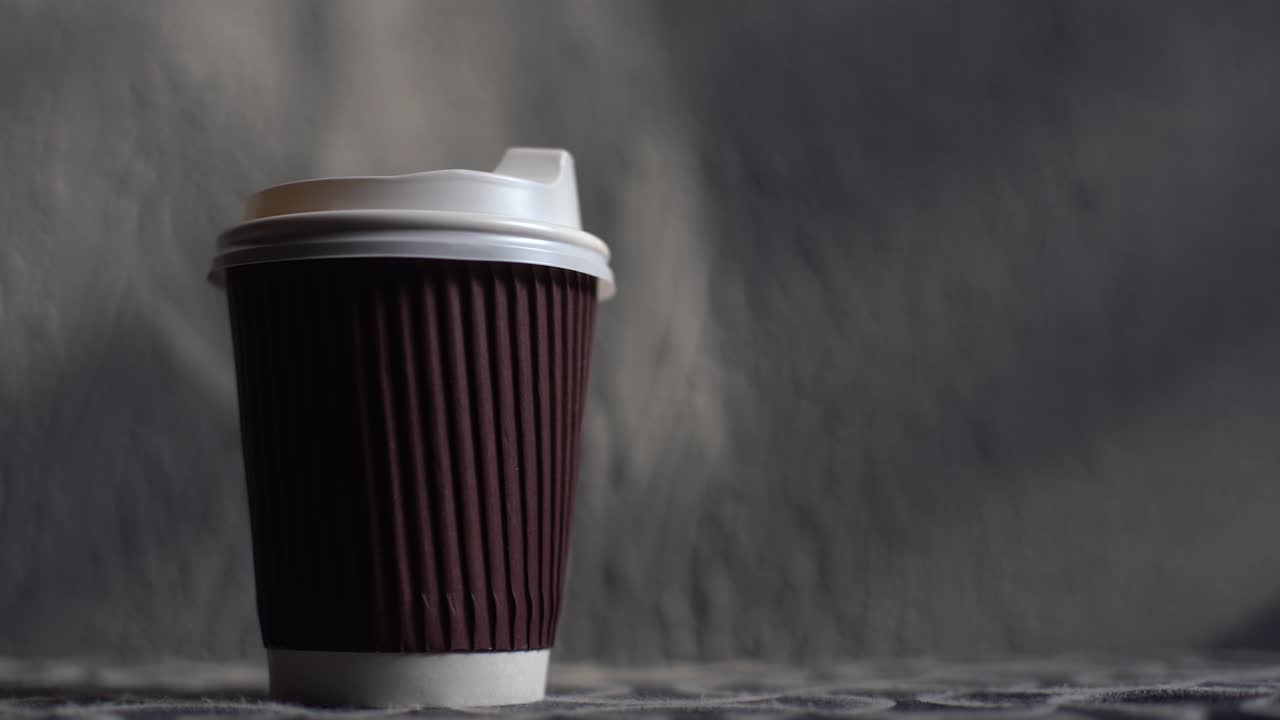 Bicchiere di caffè da asporto su uno sfondo di legno marrone