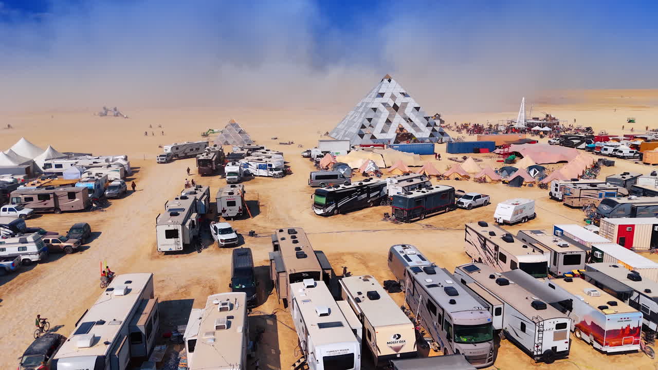 Nevada, USA, 22 August 2025: Burning Man desert camp with pyramid structures. Large pyramid installations and RVs in the desert camp during Burning Man festival