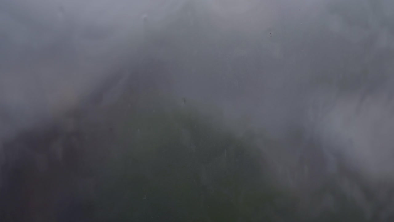 un primer plano de las gotas de lluvia en la superficie de los vidrios de las ventanas