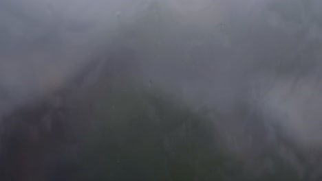 A close up shot of rain drops on window glasses surface
