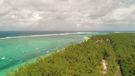 Luftaufnahme-Von-Bäumen-Unter-Wolkendecke-Am-Strand-Von-Le-Morne-Mit-Geparkten-Booten