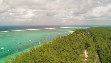 vista aérea de árboles bajo la cubierta de nubes en la playa de le morne con barcos estacionados