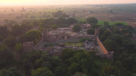 drone shot of an ancient indian fort and temple during sunset in shivpuri , india