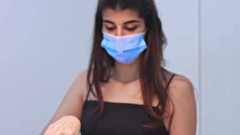 young woman cooking food for delivery in protective mask