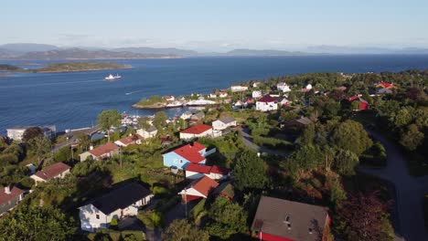 flying above sotra island with leroyosen fjord in background -- fishing vessel is heading for sea during late afternoon