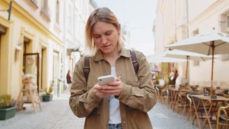 Mujer-Que-Usa-Un-Teléfono-Inteligente-Para-Enviar-Mensajes-De-Texto-En-Las-Redes-Sociales-Buscando-Una-Manera-De-Navegar-En-El-Mapa-De-La-Calle-De-La-Ciudad