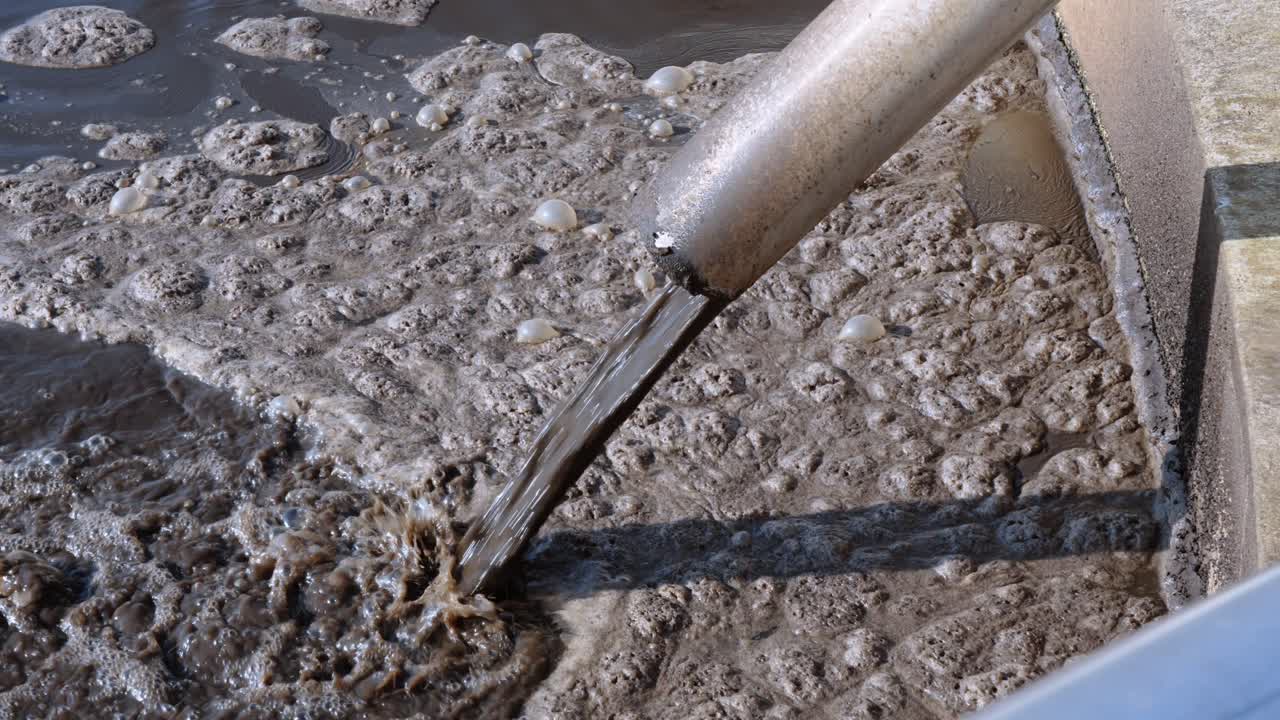Close-up of wastewater sludge processing, environmental cleanup, brown residue.