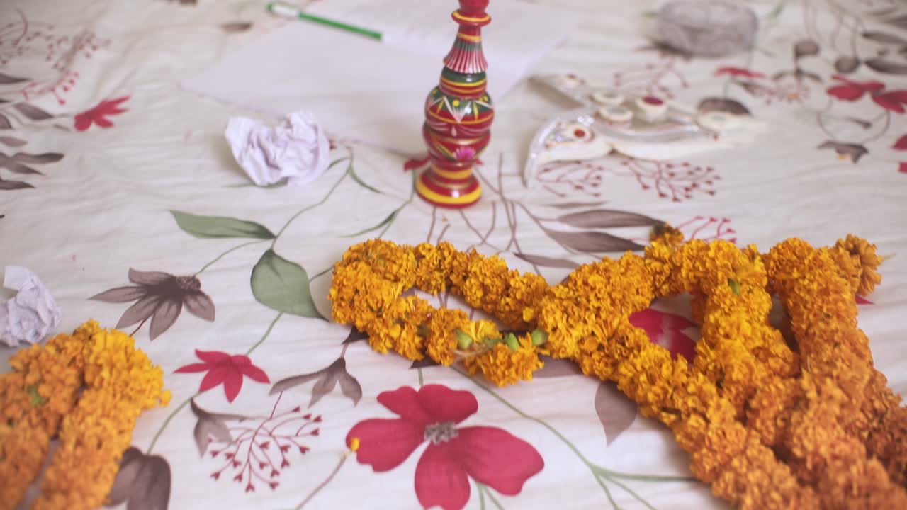 Ghirlande di fiori di calendula, carte strappate e gaachkouto sul letto, matrimonio indiano