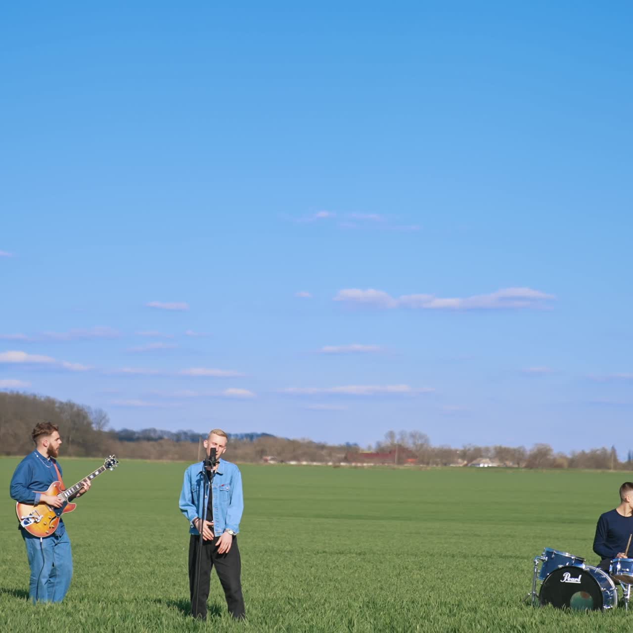 Musicians playing on field. Young musical band having concert on field