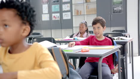 in school, children sitting at desks with colorful supplies in the classroom