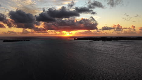 sunset on bora bora island, french polynesia. aerial view of lagoon, clouds and south pacific ocean