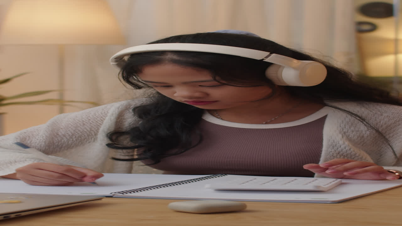 Schoolgirl in Headphones Doing Math Homework,