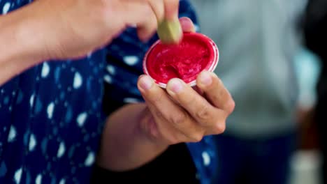 slow motion footage of a japanese man signing a nihonga, a traditional japanese painting, with a hanko, a red signature stamp