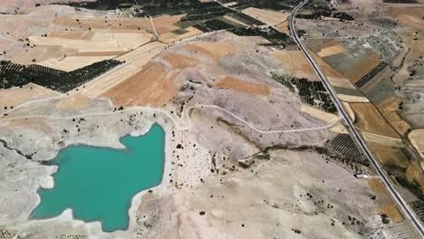 filmagem com drone de um pequeno lago perdido entre colinas e campos perto de uma estrada na turquia