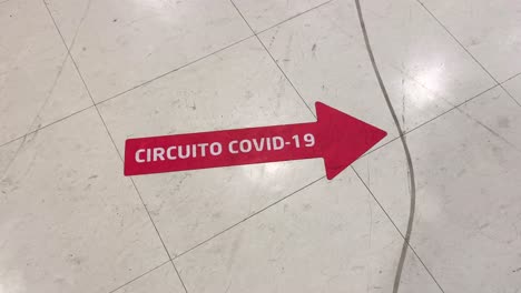 pegatina de piso de flecha roja de circuito covid en clínica - hospital