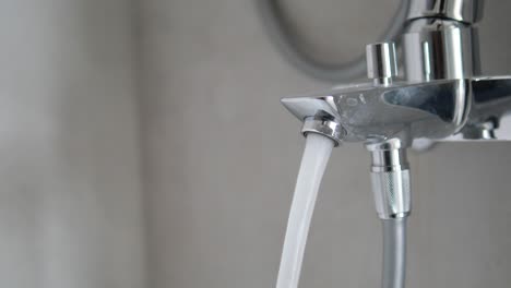 primer plano del agua que fluye de un grifo del baño