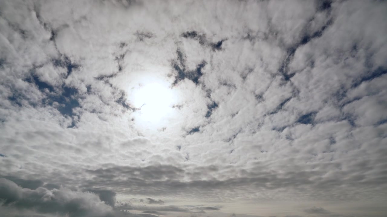 Accéléré du soleil perçant à travers des nuages altocumulus en mouvement