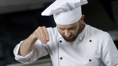 Porträt-Eines-Küchenchefs,-Der-In-Einer-Professionellen-Küche-Kocht.-Ernsthafter-Koch,-Der-Essen-Salzt.