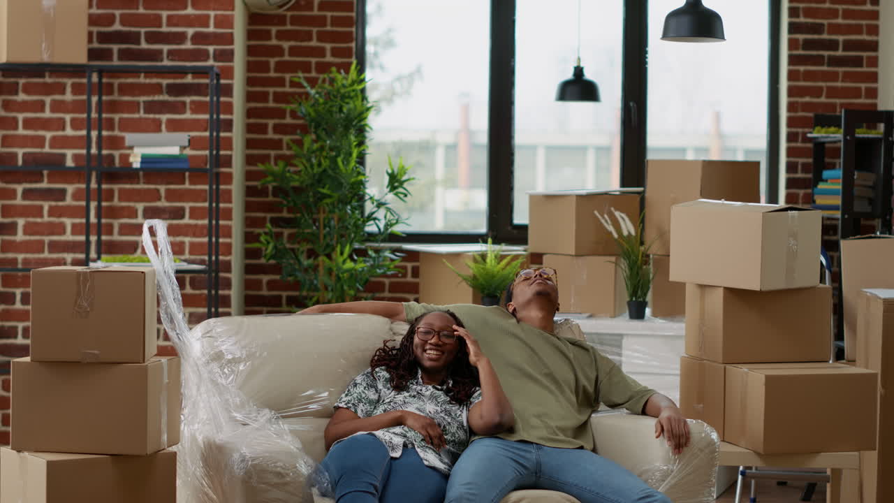 African american couple unpacking couch and furniture
