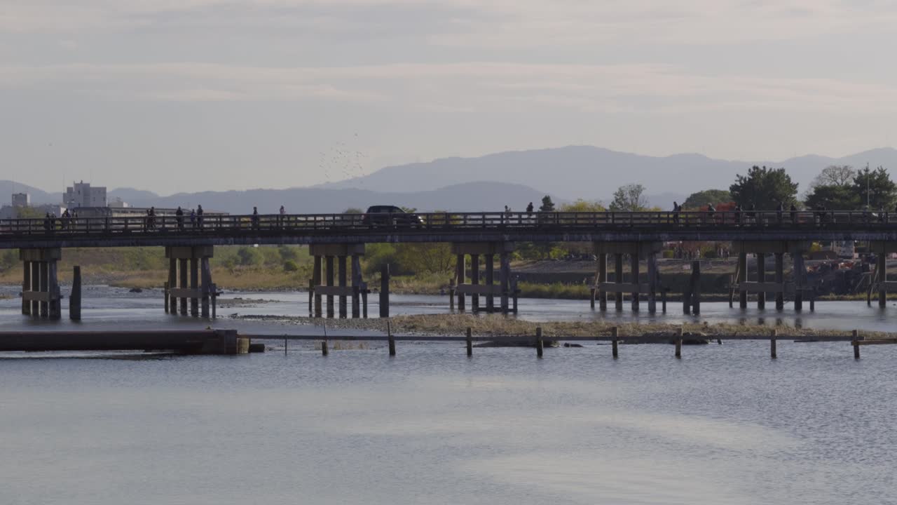 Beautiful morning scenery at Arashiyama with people walking over bridge
