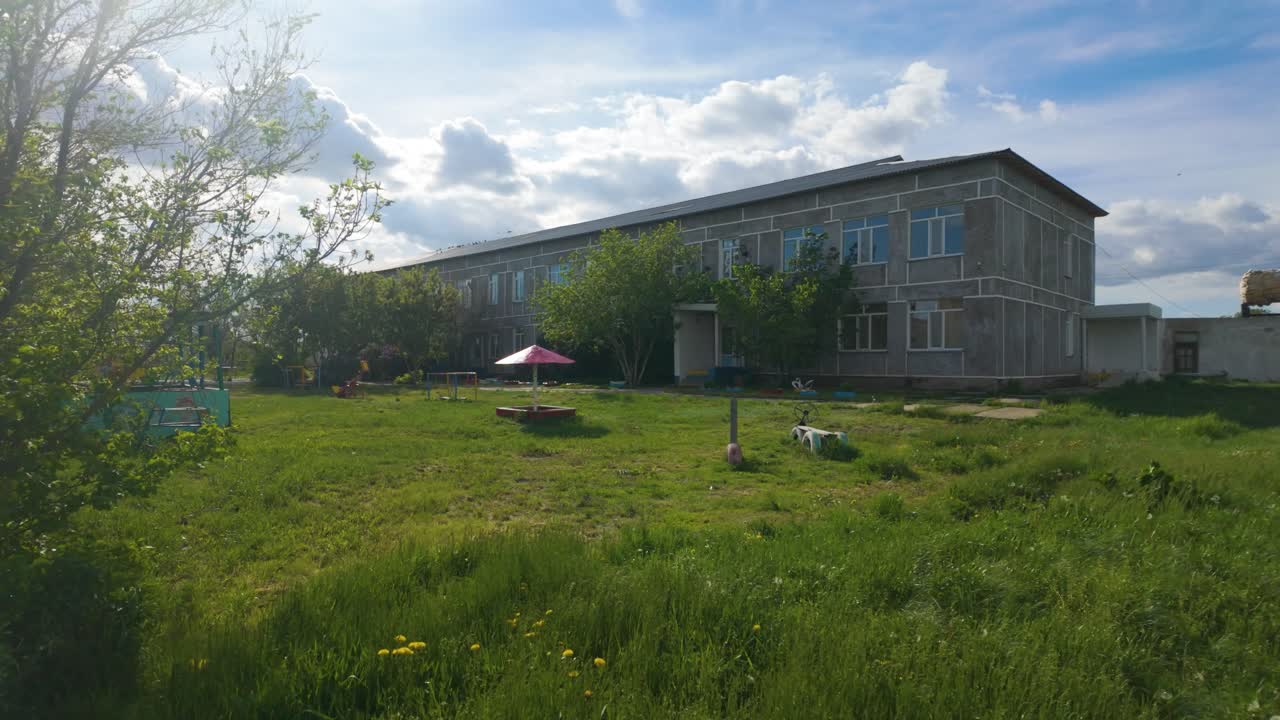 Old building with a grassy yard and playground