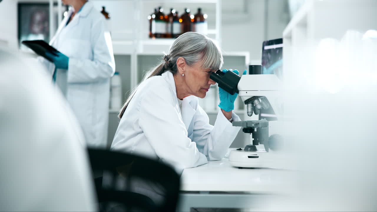 Scientist working in a lab with a microscope