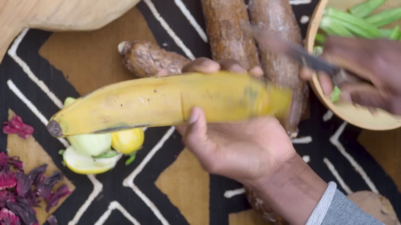 african woman holding and cutting ripe plantain as ingredient for african traditional food
