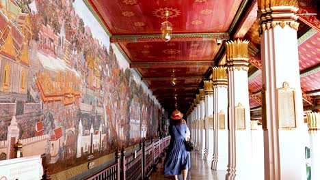 visitor admires murals in bangkok's sacred temple