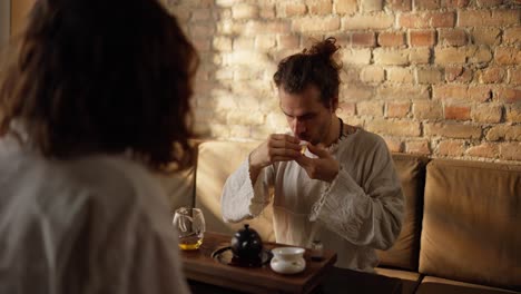 a man and a woman enjoy a cup of tea together in a cafe.