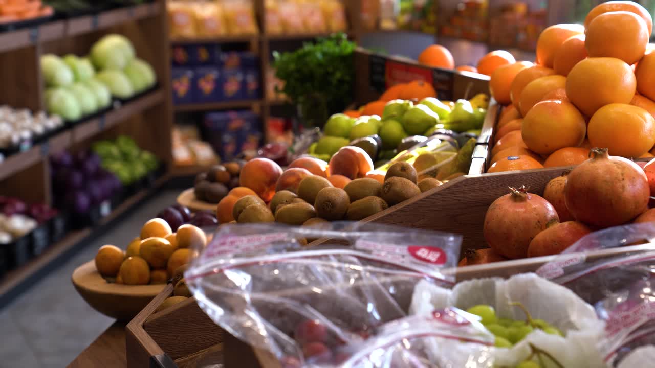 Assorted bins of colorful fruit and vegetables in market display, slow left-to-right pan.