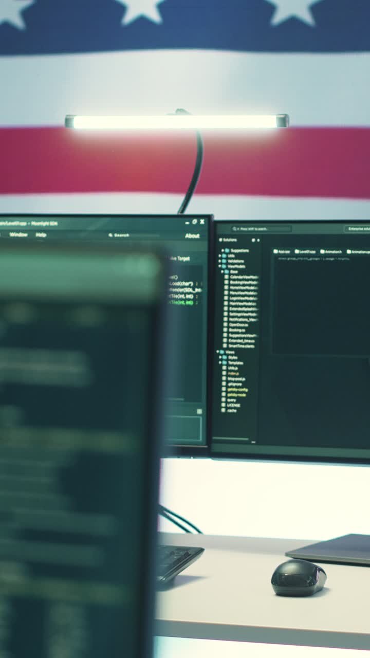 Multiple Computer Monitors Displaying Code with American Flag