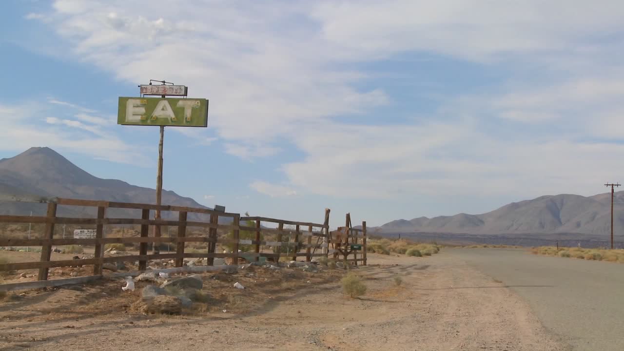 모하비 사막에서 먹는다는 표지판이 있는 버려진 식당으로의 느린 줌