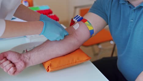female hands in blue gloves taking a blood sample for tests. hand of doctor injects a syringe into a vein of a male patient. close-up