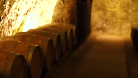 a row of wine barrels in a cellar