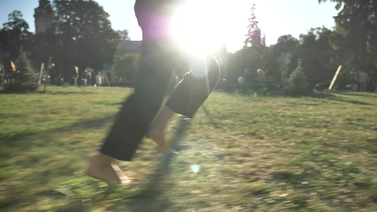 여름에 낮에 공원에서 잔디 위에서 달리는 여성의 다리, 건강한 생활 방식, 푸른 배경