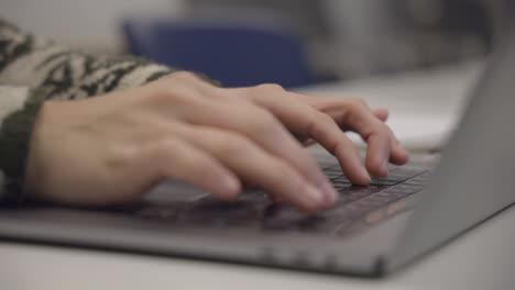 manos del hombre trabajando y escribiendo en el teclado de la computadora portátil, cerrar