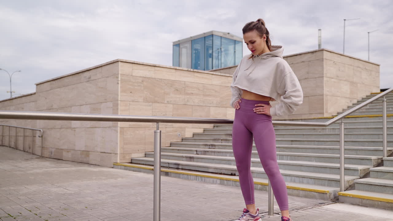 mujer haciendo un descanso de entrenamiento en las escaleras de la ciudad