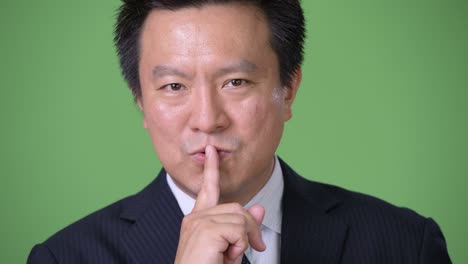 녹색 배경에 성숙한 일본 사업가