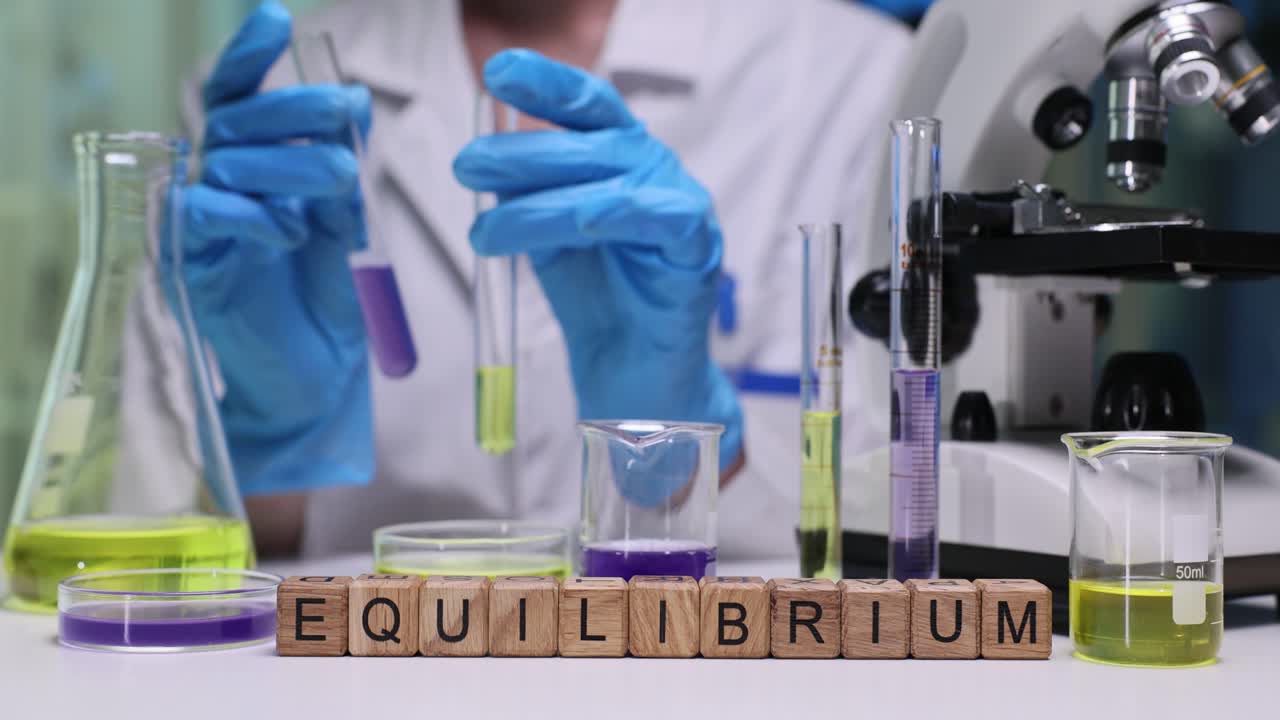 Parola equilibrio e scienziata analizza liquido colorato in laboratorio
