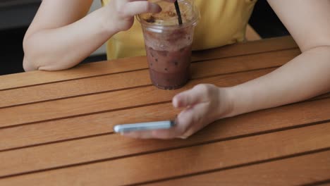 female tourist short hair wearing glasses sitting in coffee shop using touch smartphone in online shopping and social media to search for travel. women feel relaxed and happy long weekend activities.