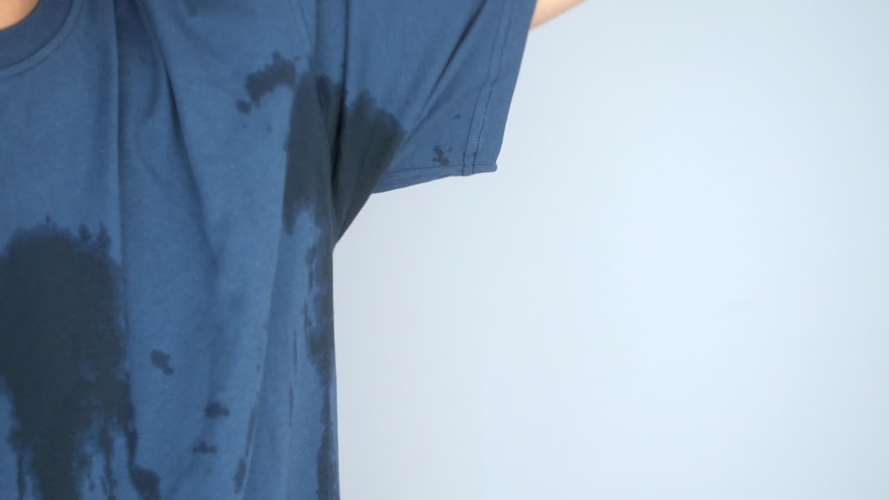 Person with sweat stains on their t-shirt