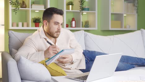 Estudiante-Universitario-Haciendo-La-Tarea-Usando-Una-Computadora-Portátil-En-Casa.