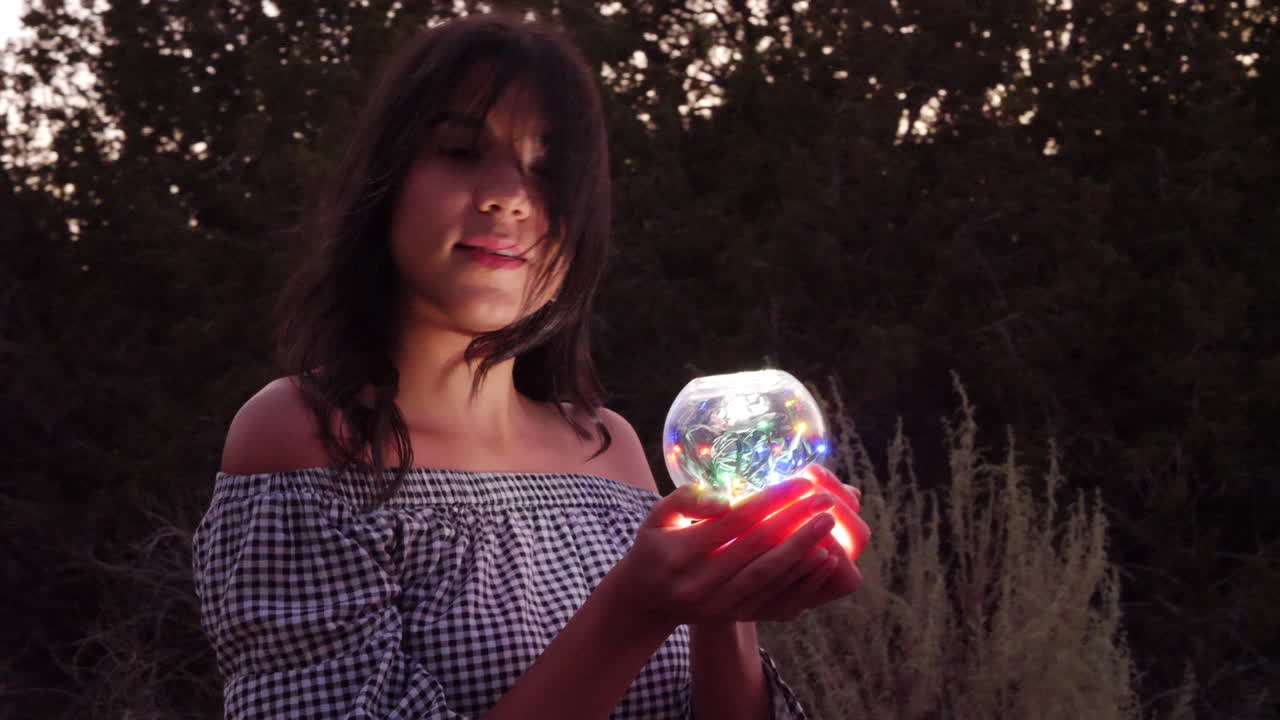 A beautiful mysterious woman on a quest with a magic glowing crystal ball in an enchanting fantasy land