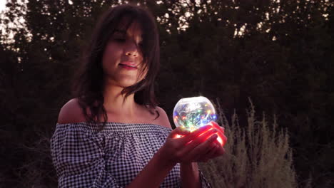 A beautiful mysterious woman on a quest with a magic glowing crystal ball in an enchanting fantasy land