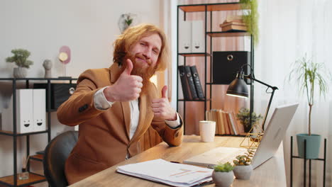 business man looking approvingly at camera showing thumbs up sign positive feedback good great news